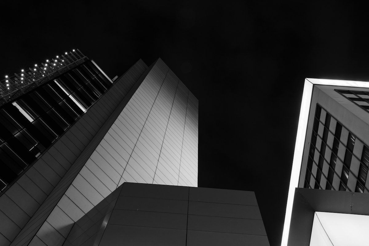Grayscale glass towers seen from below at night