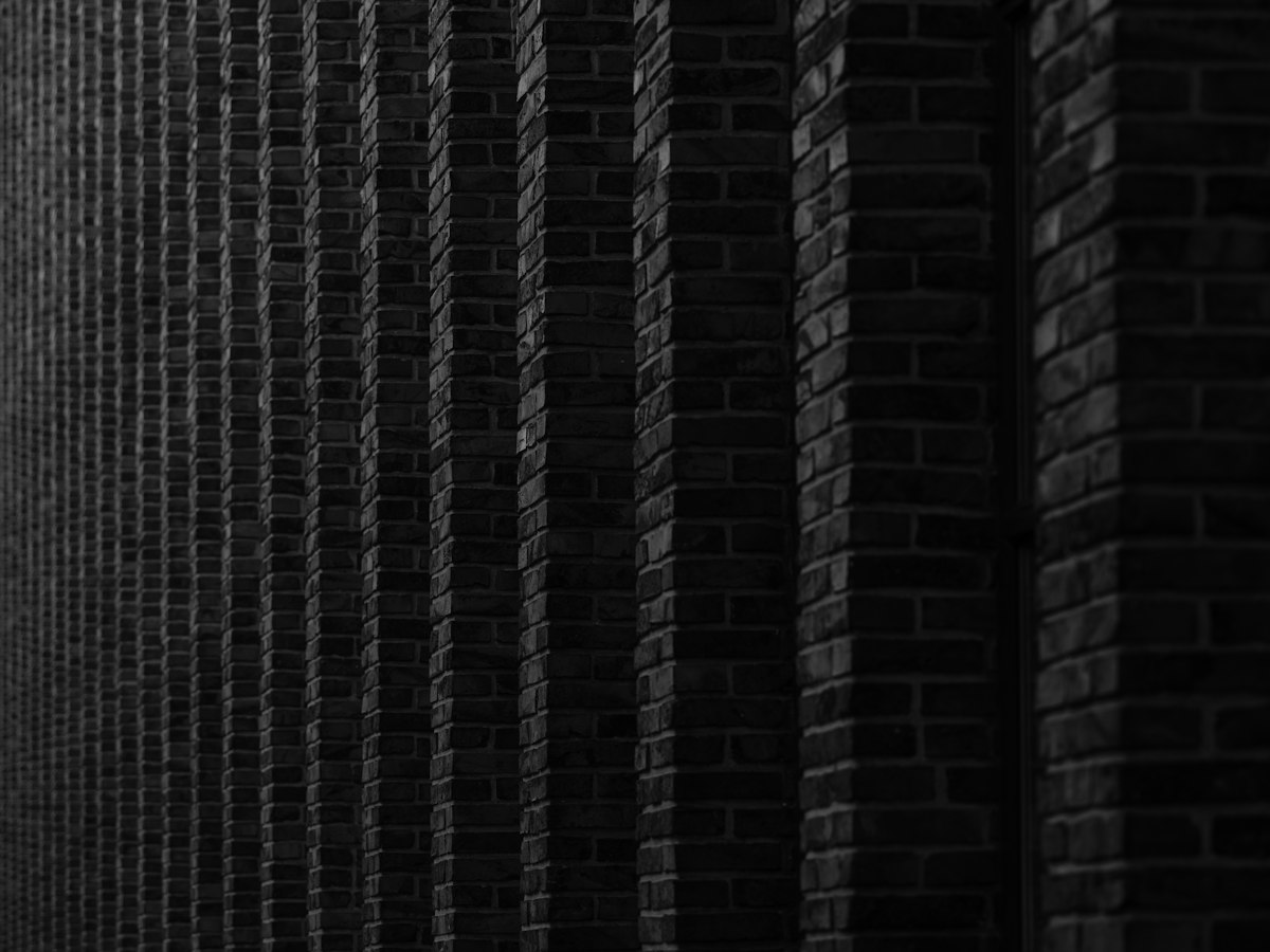 Dark brick wall with repeating vertical columns